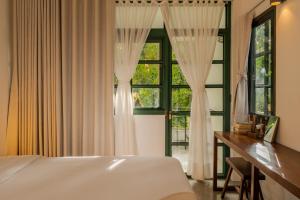 a bedroom with a bed and a desk and a window at Big Tree Boutique Hotel in Ko Tao