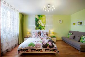 1 dormitorio con 1 cama y 1 sofá en GreenHouse Apartments Komsomolskaya, en Yekaterinburg