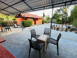 eine Terrasse mit vier Stühlen und einem Tisch und ein Haus in der Unterkunft Wildlife stay in Kakkabe + 2 Fotos