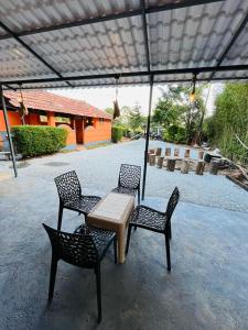 2 Stühle und ein Tisch mit einem Tisch und 2 Stühlen in der Unterkunft Wildlife stay in Kakkabe