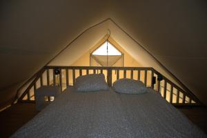 Giường trong phòng chung tại Glampingtent de Deiling, de Woudhaven