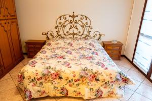 a bedroom with a bed with a floral bedspread at Appartamento Clivo in Solto Collina