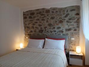 een slaapkamer met een bed met twee lampen op tafels bij Comelico CasaVacanza in Santo Stefano di Cadore