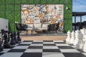 una scacchiera con sedie e una parete con un murale di Miami Skyline Residences by Untitled Stay a Miami