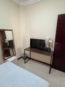 a bedroom with a television and a table with a mirror at Quarto em apartamento in Ouro Preto
