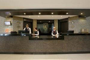 three people sitting at a counter in a lobby at Kaya Prestige in İzmir