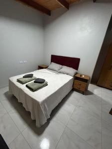 ein Schlafzimmer mit einem großen weißen Bett mit zwei Handtüchern darauf in der Unterkunft Cabañas Luna 