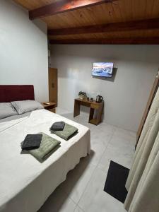 ein Schlafzimmer mit einem Bett und einem Fernseher an der Wand in der Unterkunft Cabañas Luna 