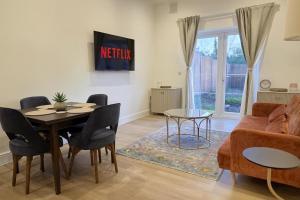 een woonkamer met een tafel en een bank bij Louisville Flat 4 in Newmarket