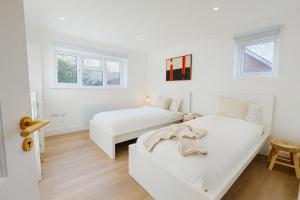 een witte slaapkamer met 2 bedden en een bank bij Louisville Flat 4 in Newmarket