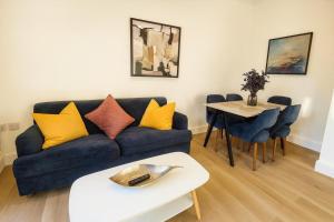 een woonkamer met een bank en een tafel bij Louisville Flat 3 in Newmarket