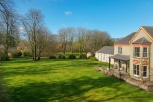 een huis met een grote tuin met groen gras bij Louisville Flat 3 in Newmarket