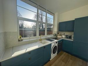een keuken met een spoelbak en een wasmachine bij Louisville Flat 3 in Newmarket