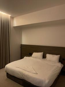 een slaapkamer met een groot bed met witte lakens en kussens bij المدينة المنورة in Al Madinah