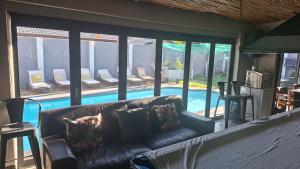 een woonkamer met een bank en een zwembad bij Robert's Place Paarl in Paarl