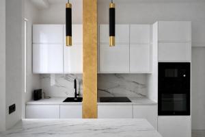 una cucina bianca con armadietti bianchi ed elettrodomestici neri di Maison Chanel a Milano