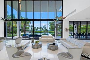 un soggiorno con mobili bianchi e ampie finestre di Elysium Ocean Exclusive Villa a Dorado