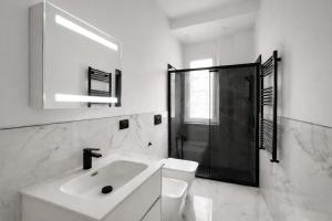 un bagno bianco con lavandino e doccia di Maison Chanel a Milano