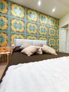 a bedroom with a bed and a wall with colorful tiles at La Chicca di Ameli in San Severo