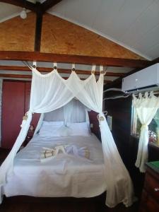 - une chambre avec un grand lit et des rideaux blancs dans l'établissement Pousada & Hostel Interligado Tiririca, à Itacaré