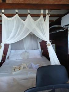 une chambre avec un lit blanc à baldaquin dans l'établissement Pousada & Hostel Interligado Tiririca, à Itacaré 24 autres photos