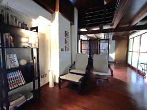 ein Wohnzimmer mit 2 Stühlen und einem Bücherregal in der Unterkunft Casa del Mirador in Arjona