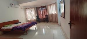 ein Schlafzimmer mit einem Bett und einem Stuhl in einem Zimmer in der Unterkunft Chavan White House Farm and Stay in Badlapur