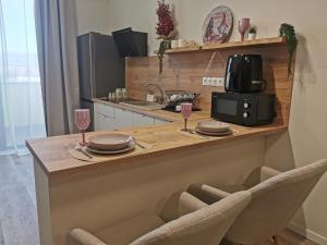 een keuken met een tafel met twee glazen wijn bij River Apartman 1 in Odorheiu Secuiesc