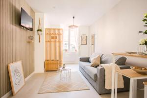 a living room with a couch and a table at Idéal PRO & Couple - 2 Logements Thème Boho Chic RDC & Dandy 1er étage - Quartier Calme - Jardin - WIFI HD - Smart TV - Parking Gratuit - Proche Centre & Transports - Ask Home in Valenciennes