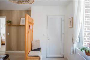 a living room with a chair and a door at Idéal PRO & Couple - 2 Logements Thème Boho Chic RDC & Dandy 1er étage - Quartier Calme - Jardin - WIFI HD - Smart TV - Parking Gratuit - Proche Centre & Transports - Ask Home in Valenciennes