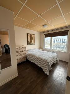 a bedroom with a bed and a window at Apartment #2 avec chambre Baie Comeau in Baie-Comeau