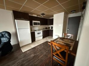 a small kitchen with a table and a refrigerator at Apartment #2 avec chambre Baie Comeau in Baie-Comeau
