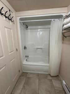 a bath tub in a bathroom with a shower at Apartment #2 avec chambre Baie Comeau in Baie-Comeau