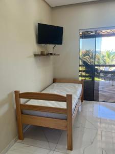a bedroom with a bed and a flat screen tv at Loft Sol e Mar Exclusivo em Bombinhas 50m da praia in Bombinhas