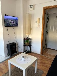 ein Wohnzimmer mit einem Tisch und einem Fernseher an der Wand in der Unterkunft Kneginje Ljubice apartment in Belgrad