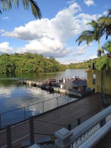 un molo con barche su un fiume con palme di Casa das Plantas a Piraju