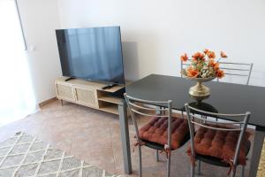 einem Esstisch mit 2 Stühlen und einem TV in der Unterkunft Alojamento Bem-me-quer in Reguengos de Monsaraz