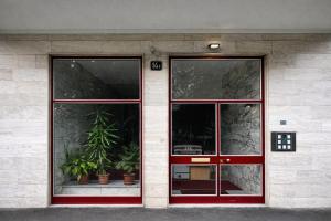 una porta rossa di un edificio con piante in vaso di Maison Chanel a Milano