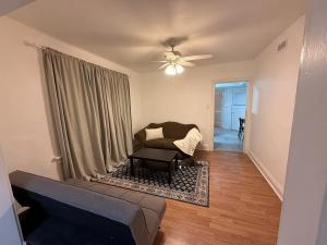 ein Wohnzimmer mit einer Couch und einem Deckenventilator in der Unterkunft Delmar Loop 2-Bedroom Retreat in University City
