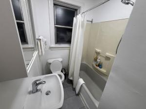 a bathroom with a sink and a toilet and a shower at Delmar Loop 2-Bedroom Retreat in University City