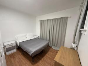 a small bedroom with a bed and a window at Delmar Loop 2-Bedroom Retreat in University City