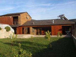 una grande casa in mattoni con un prato di Casa do Lagar ad Alvarenga