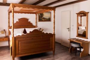 巴登-巴登Landhotel Traube的一间卧室配有一张天蓬床和一张书桌