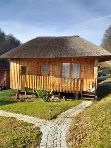 a wooden house with a thatched roof at Glamping Bionic healing village in Slovenska Bistrica