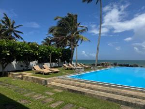 a swimming pool with a view of the ocean at Silverlane Beach House in Matara