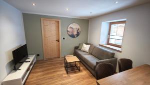 a living room with a couch and a table at Chasa Salnuun Ferienwohnungen in Samnaun +3 photos