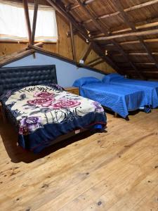 een slaapkamer met 2 bedden op een zolder bij El refugio de los sueños in Duggan +4 foto's