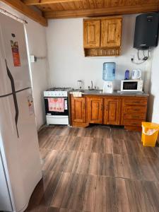 een keuken met houten vloeren en een koelkast in een kamer bij El refugio de los sueños in Duggan