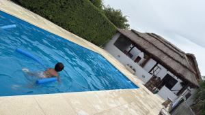 Een vrouw bevindt zich in een zwembad met een zwemband. bij El refugio de los sueños in Duggan