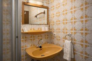 une salle de bains avec un lavabo et un miroir dans l'établissement Pension zur Quelle, à Deudesfeld